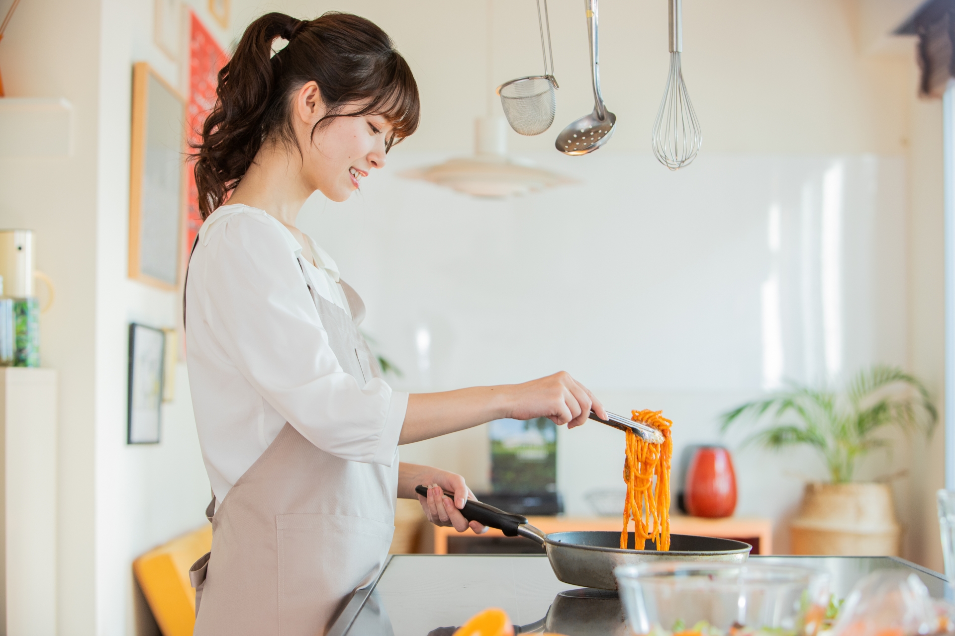 夏場、キッチンで料理をしている女性